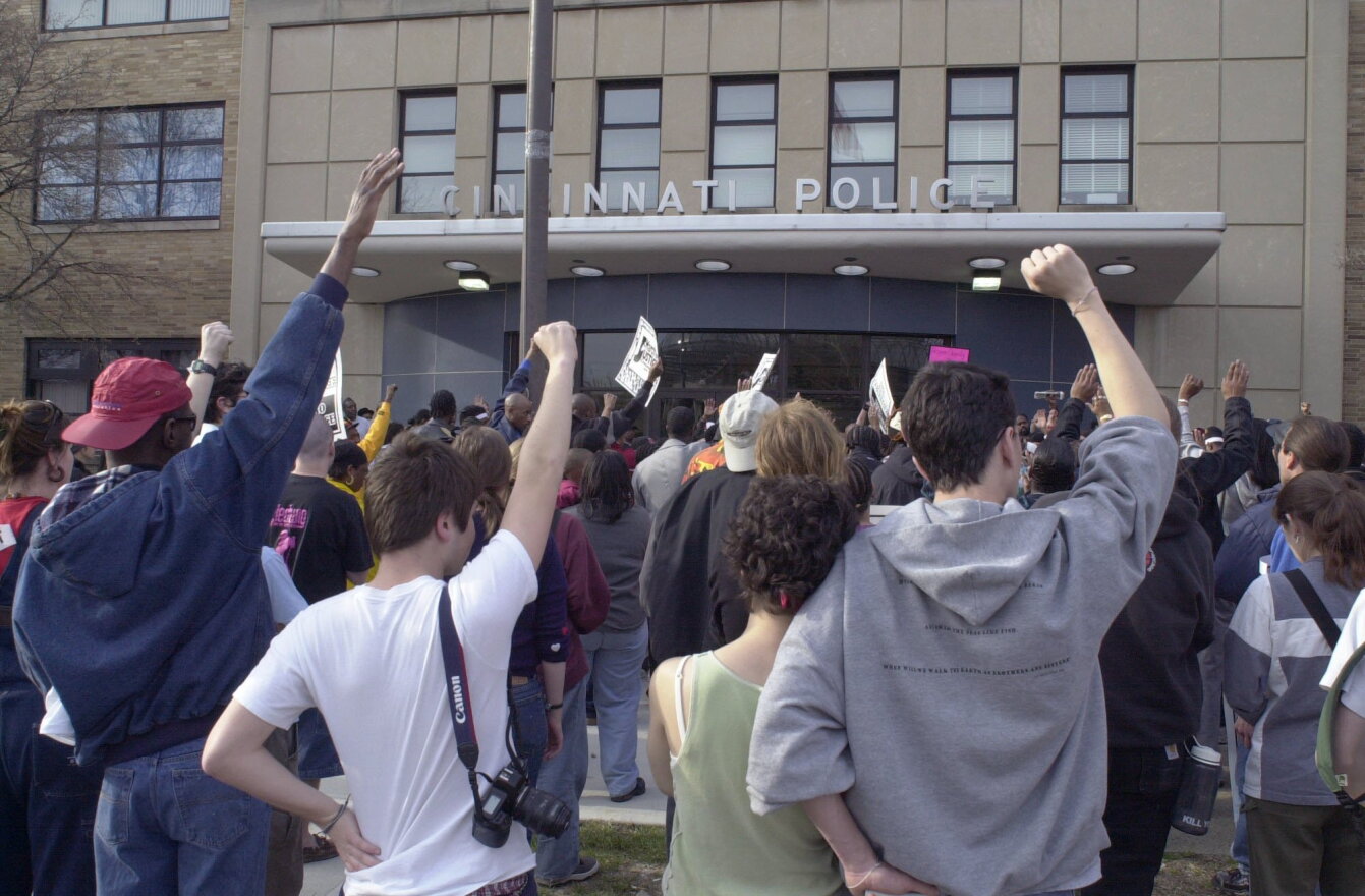 Protesters demonstrate outside the District One police station in Cincinnati, Sunday, April 7, 2002, during a rally to mark the one-year anniversary of the fatal shooting of Timothy Thomas, an unarmed black man, by a white police officer. 